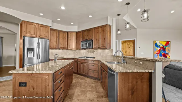 a large kitchen with stainless steel appliances granite countertop a sink refrigerator and cabinets