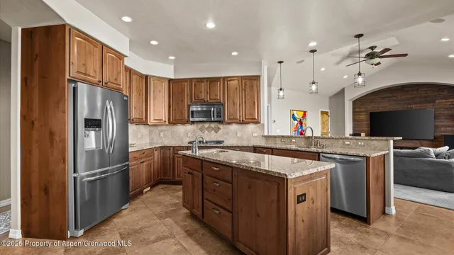 a kitchen with stainless steel appliances granite countertop a stove top oven a refrigerator a sink and dishwasher