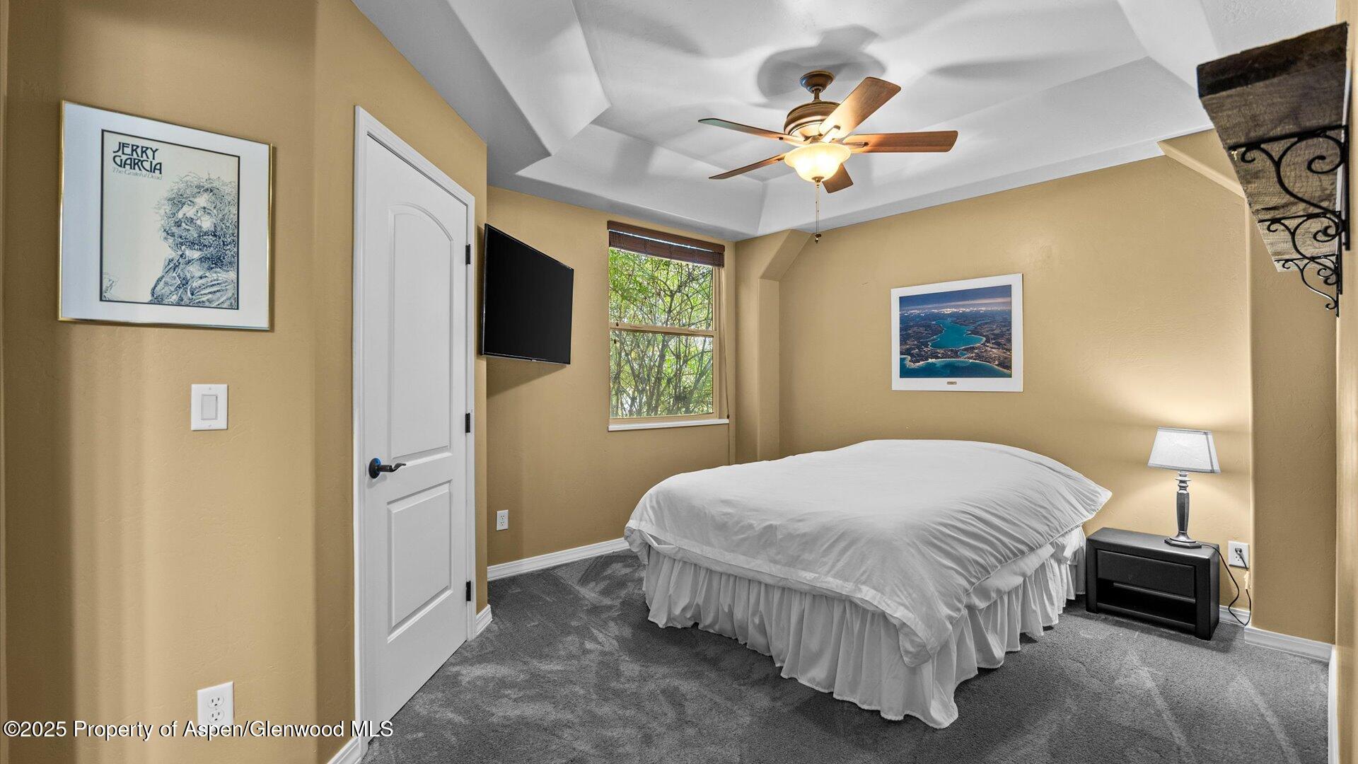 1984 J Road Fruita, CO 81521 - Photo 27 of 40 a bedroom with a bed and a chandelier