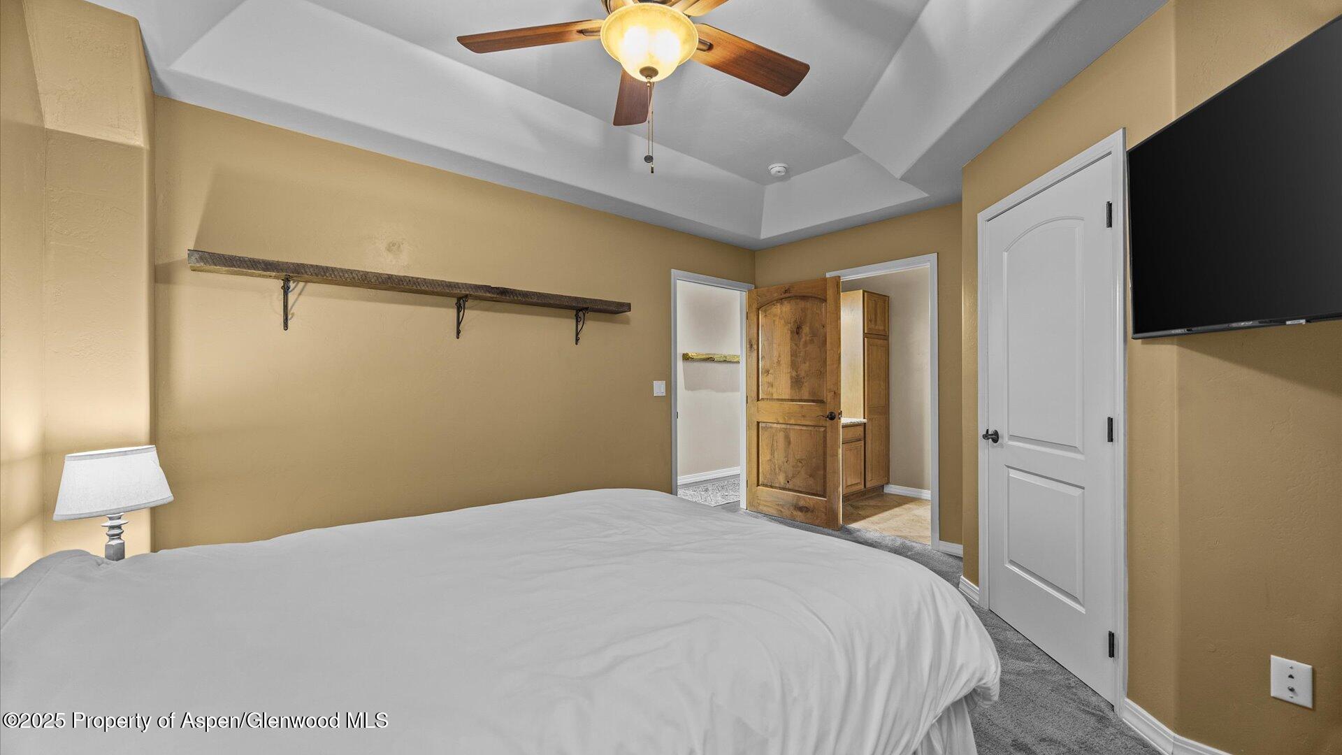 1984 J Road Fruita, CO 81521 - Photo 28 of 40 a bedroom with a bed and a chandelier