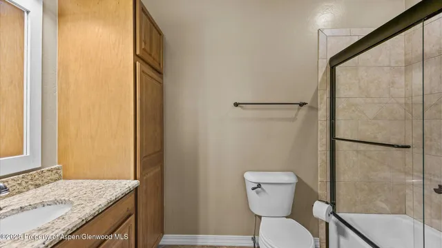 a bathroom with a granite countertop sink toilet and shower