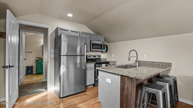 a kitchen with stainless steel appliances granite countertop a refrigerator a sink and a stove
