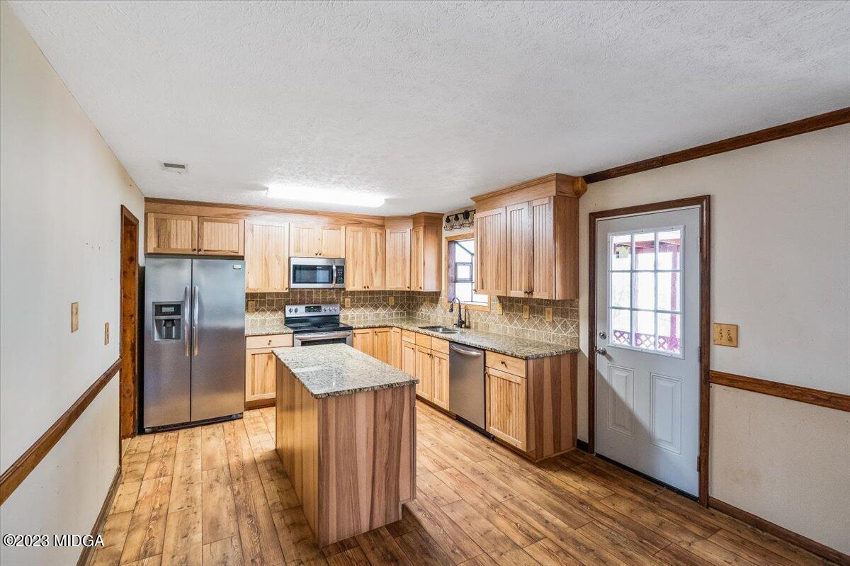 546 Old Union Gin Road Forsyth, GA 31029 - Photo 8 of 23 a kitchen with stainless steel appliances granite countertop a refrigerator a sink dishwasher a stove and white countertops with wooden floor