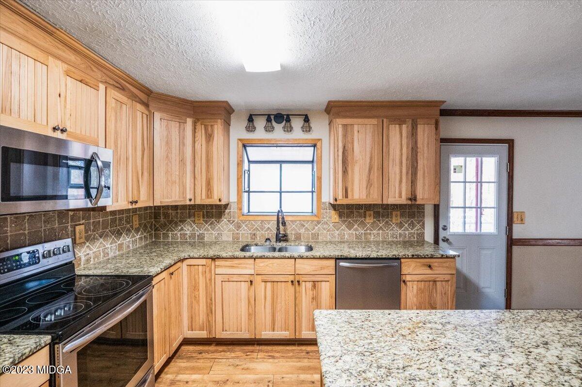 546 Old Union Gin Road Forsyth, GA 31029 - Photo 9 of 23 a kitchen with kitchen island granite countertop a sink cabinets stainless steel appliances and a window