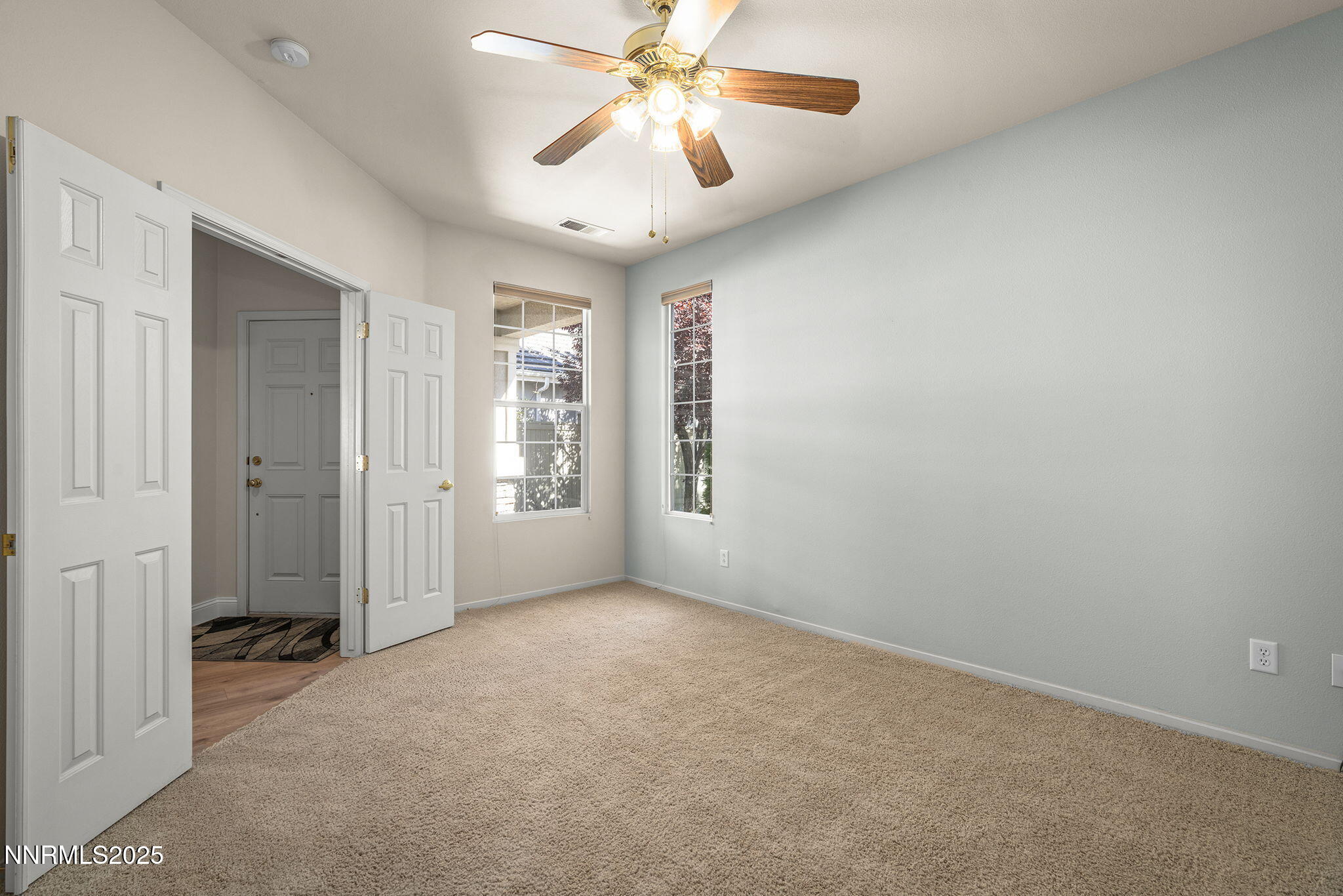 10145 Donner Peak Drive Reno, NV 89521 - Photo 17 of 32 an empty room with chandelier fan and windows