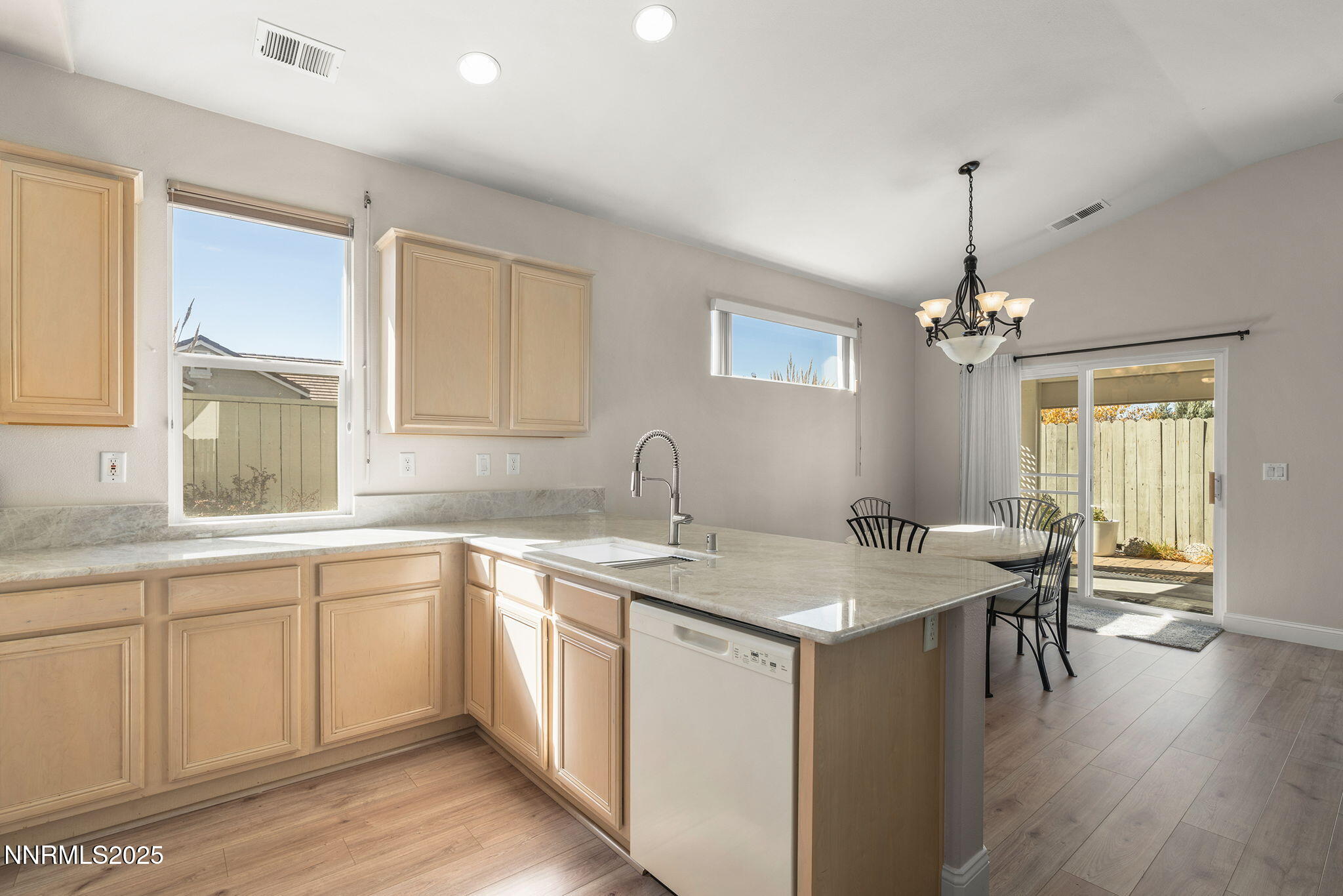 10145 Donner Peak Drive Reno, NV 89521 - Photo 7 of 32 a white kitchen with a sink and dishwasher with wooden floor