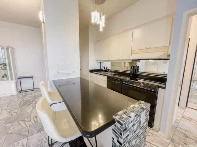 a kitchen with stainless steel appliances granite countertop a sink a stove a table and chairs