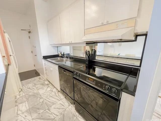 a kitchen with kitchen island granite countertop a sink stove and cabinets
