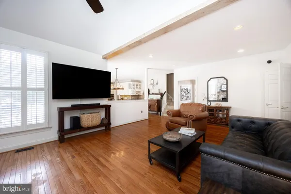 a kitchen with stainless steel appliances granite countertop a stove a sink dishwasher a refrigerator with a dining table and chairs with wooden floor