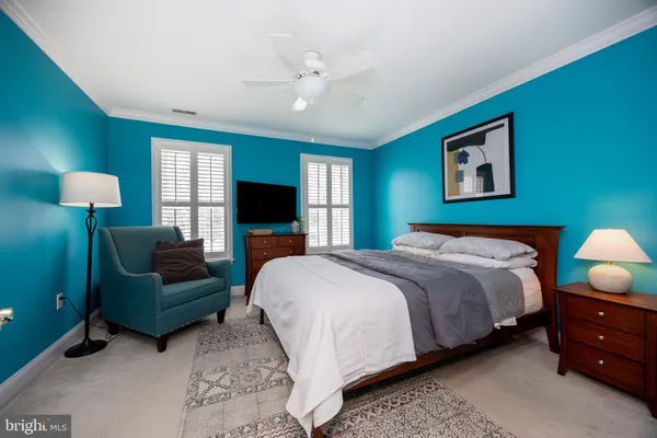 a bedroom with a bed and a flat tv screen on dresser