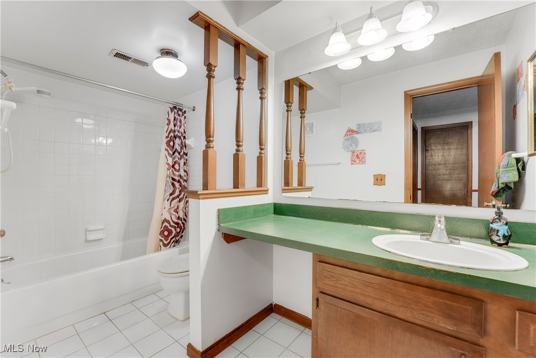 123 Boulder Ridge Place Painesville, OH 44077 - Photo 26 of 28 Full bathroom featuring shower / tub combo with curtain, light tile patterned floors, and vanity