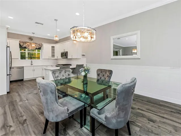 a view of a dining room with furniture a chandelier and wooden floor