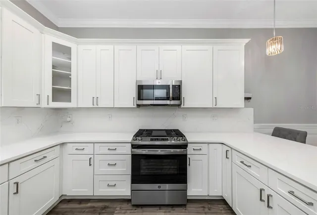 a kitchen with white cabinets and black appliances