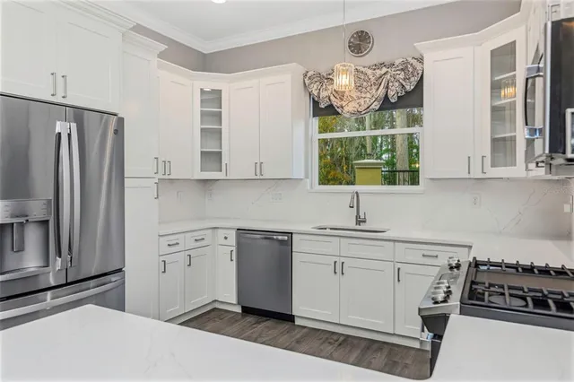 a kitchen with stainless steel appliances a stove a sink and a refrigerator