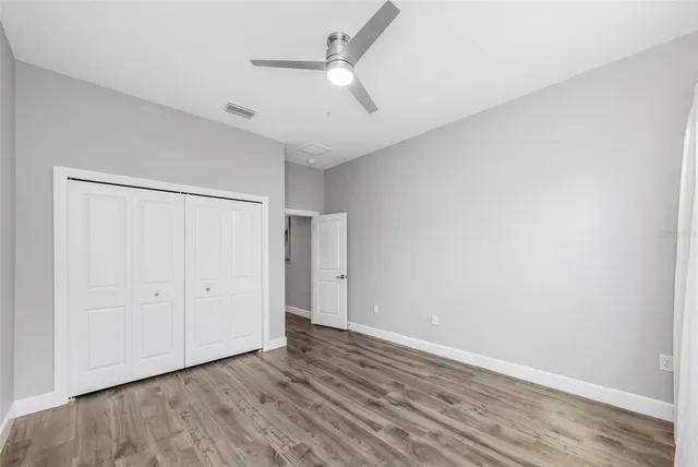 a bathroom with a granite countertop toilet a sink a mirror and a shower