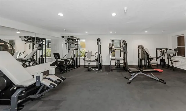 a front view of a multi story residential apartment building with yard and bench