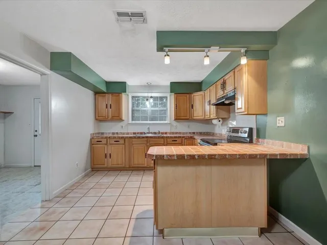 a kitchen with stainless steel appliances granite countertop a sink stove and cabinets