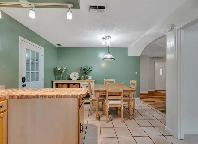 a room with stainless steel appliances kitchen island a table and chairs in it