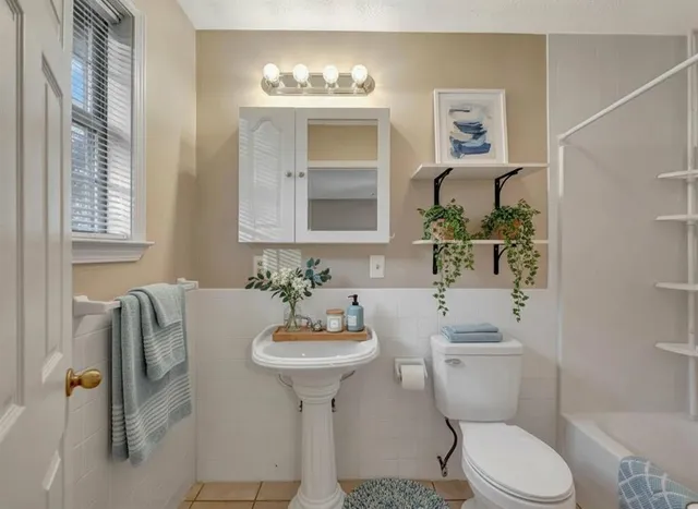 a bathroom with a sink toilet and mirror