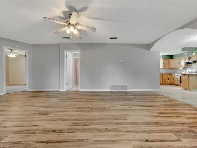 a view of a livingroom with wooden floor and a ceiling fan