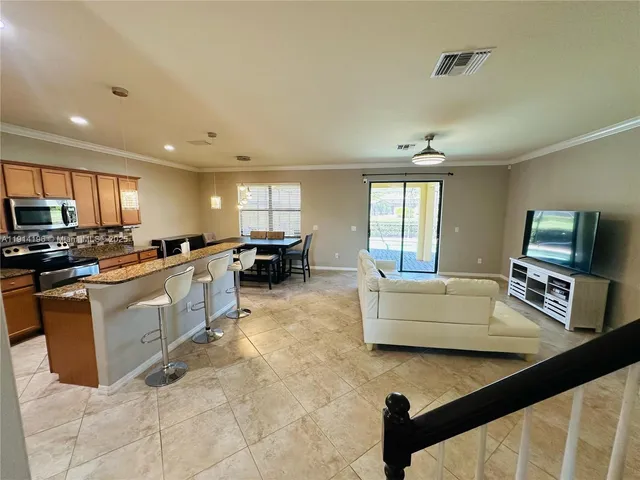 a kitchen with stainless steel appliances granite countertop a sink counter space cabinets and a couch