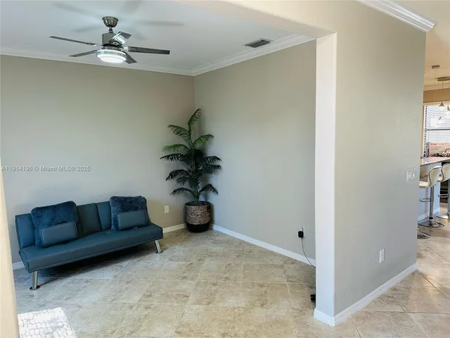 a living room with furniture and a chandelier fan