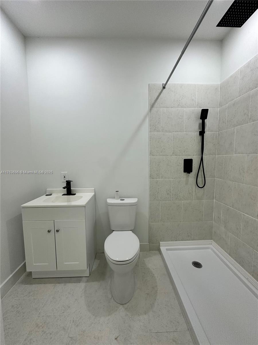 13137 Southwest 284th Street, Unit B Homestead, FL 33033 - Photo 2 of 11 a bathroom with a sink a toilet and shower