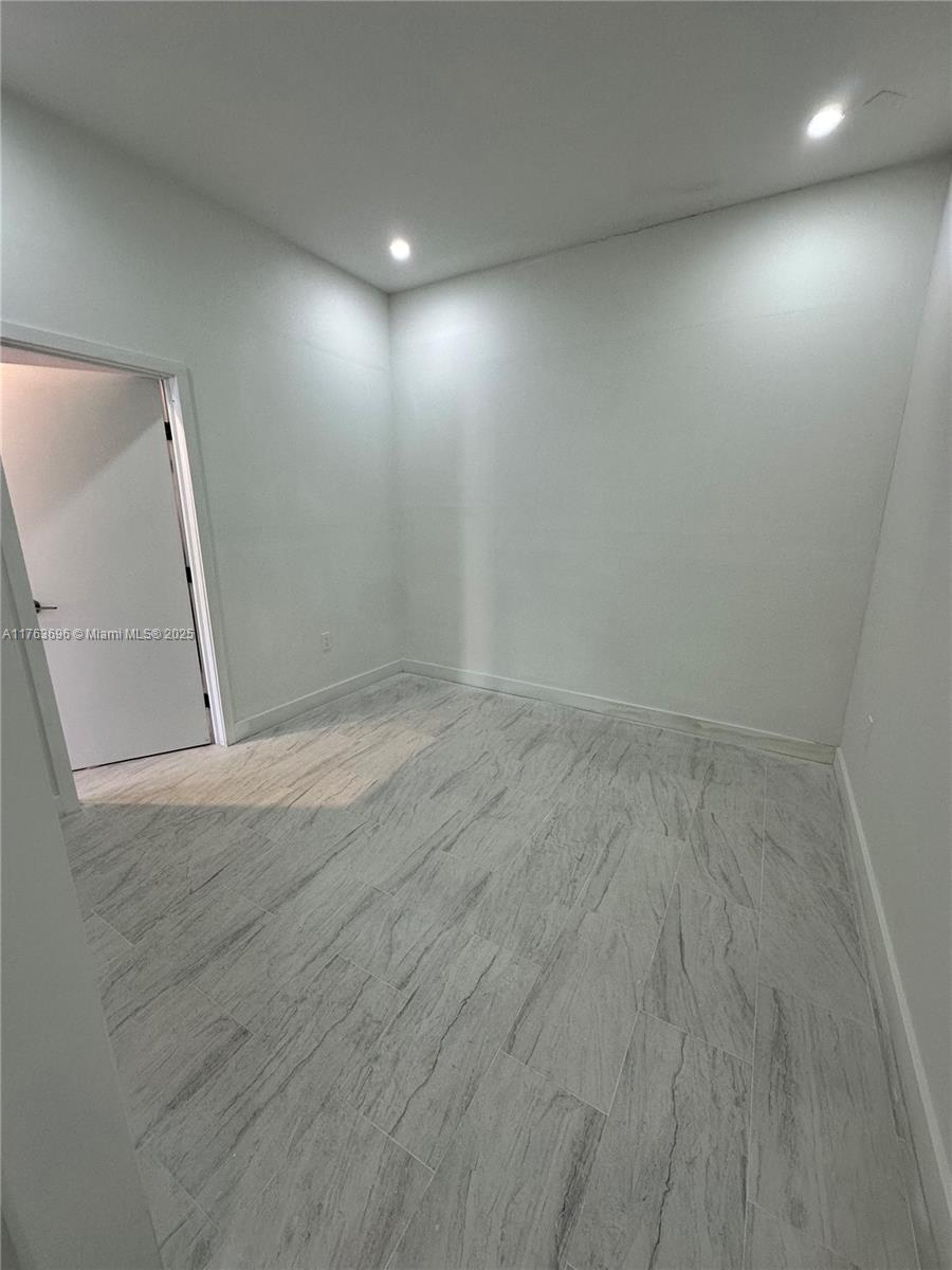 13137 Southwest 284th Street, Unit B Homestead, FL 33033 - Photo 5 of 11 an empty room with wooden floor and mirror