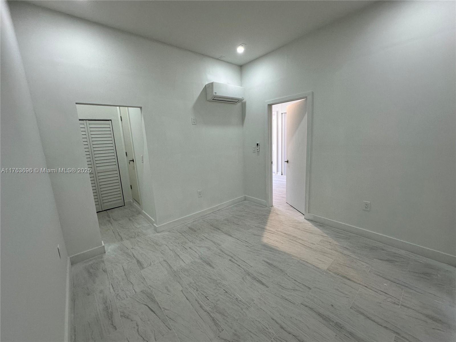 13137 Southwest 284th Street, Unit B Homestead, FL 33033 - Photo 6 of 11 an empty room with wooden floor and mirror