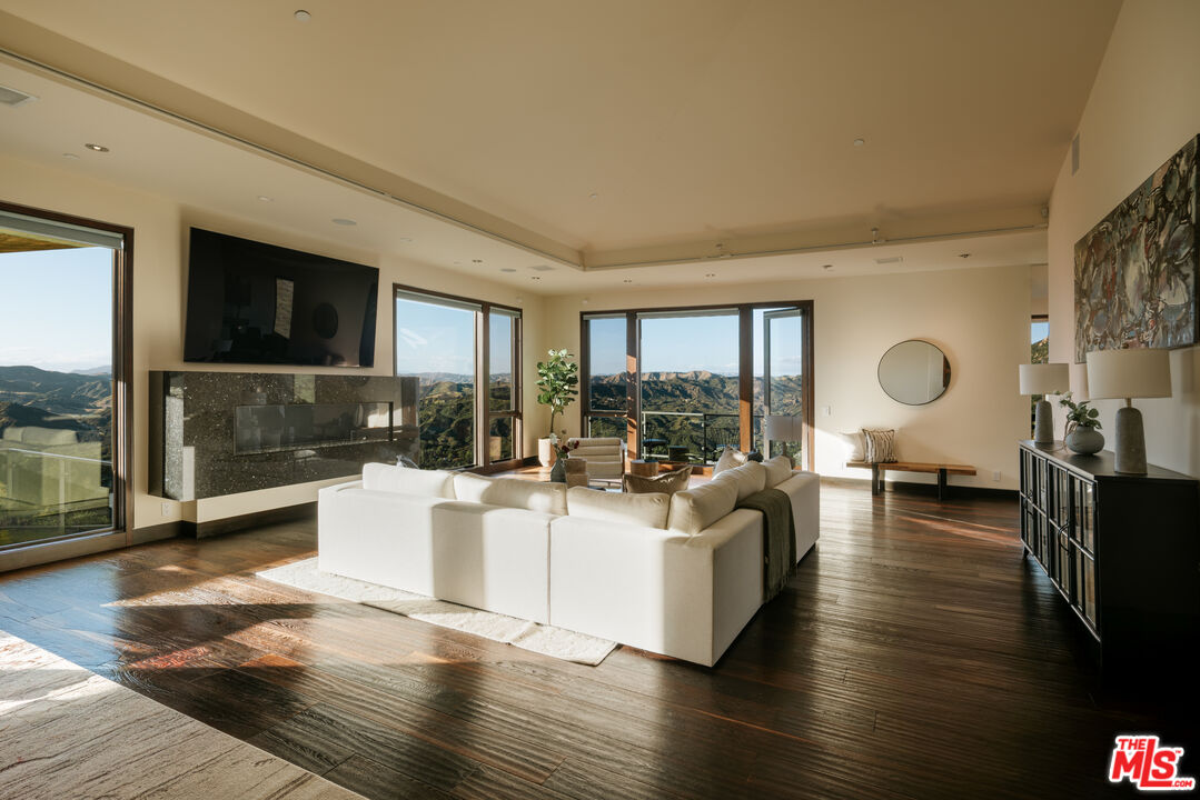 25155 Piuma Road Malibu, CA 90265 - Photo 15 of 23 a living room with fireplace furniture and a flat screen tv