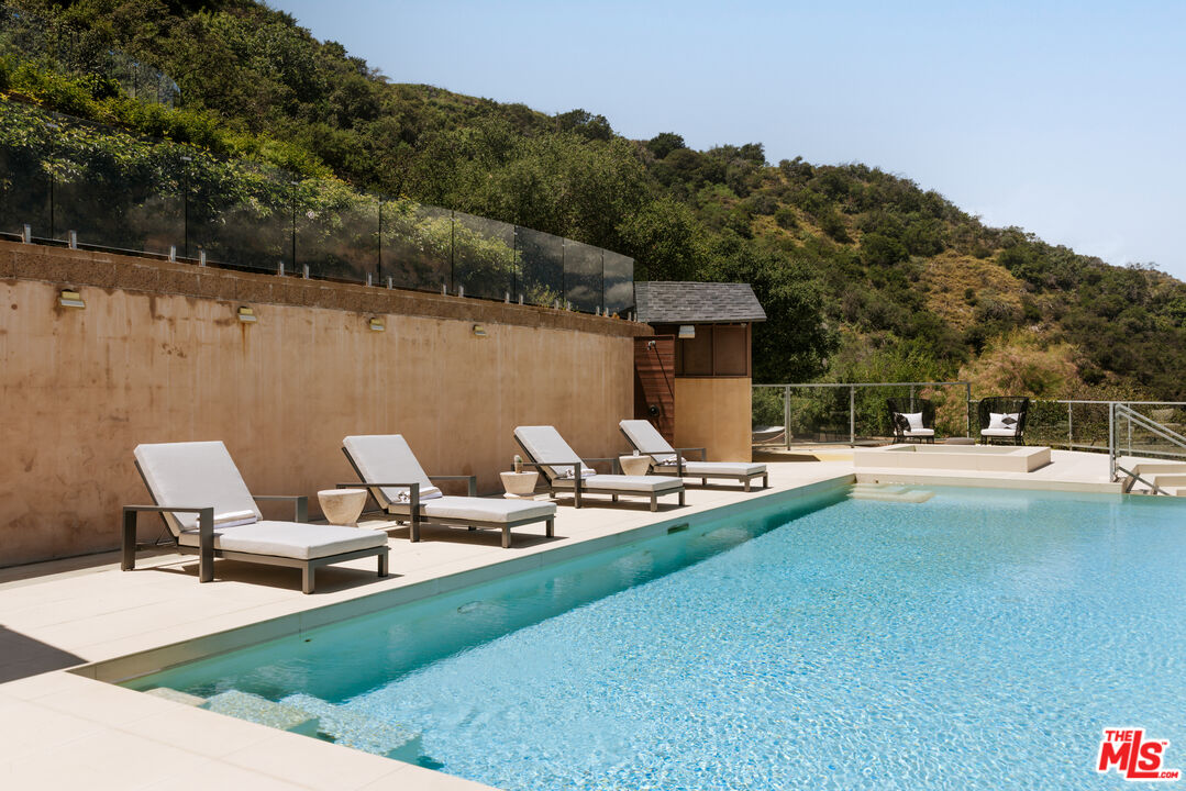 25155 Piuma Road Malibu, CA 90265 - Photo 19 of 23 a view of a patio with a table chairs and a swimming pool