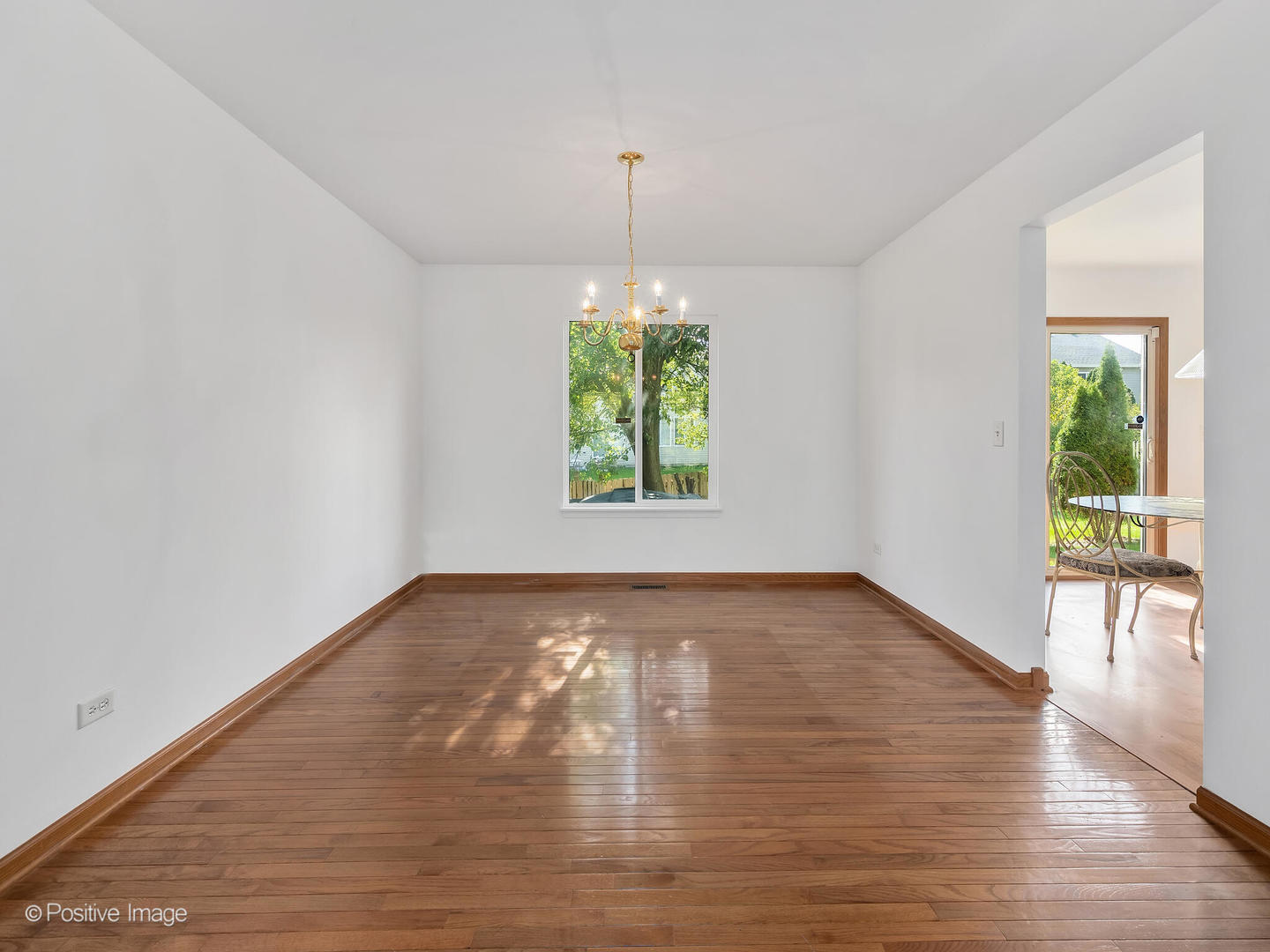 215 Berkeley Drive Bolingbrook, IL 60440 - Photo 7 of 28 a view of a room with window wooden floor and a chandelier