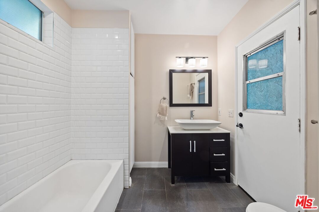 4908 Ramsdell Avenue La Crescenta, CA 91214 - Photo 22 of 29 a bathroom with a sink a mirror and bathtub