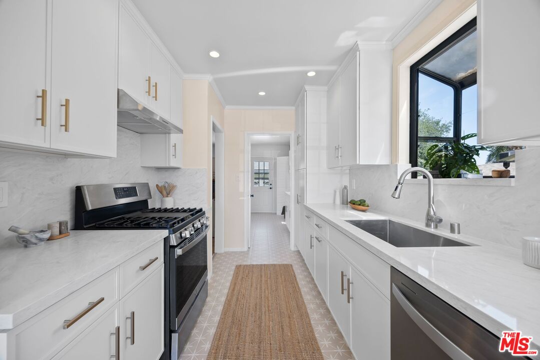 4908 Ramsdell Avenue La Crescenta, CA 91214 - Photo 9 of 29 a kitchen with a sink dishwasher stove and white cabinets with wooden floor