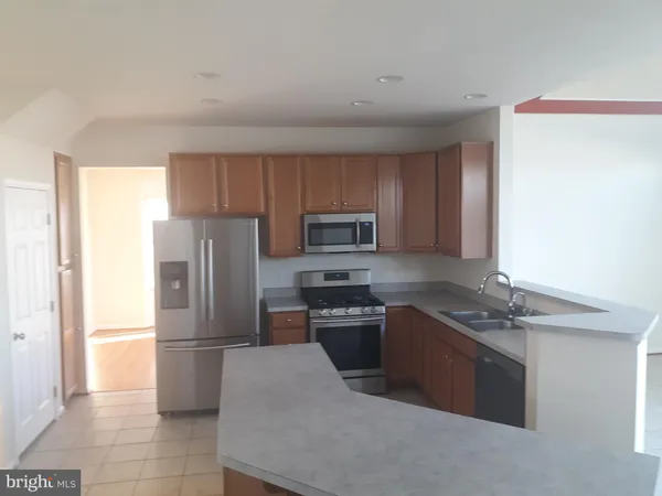 a kitchen with stainless steel appliances granite countertop a refrigerator stove a sink and dishwasher
