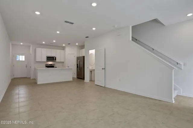 a view of a kitchen with a sink and white cabinets