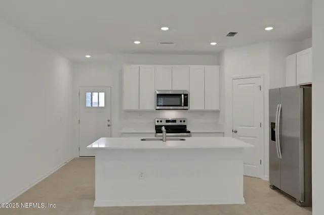 a kitchen with stainless steel appliances a refrigerator stove microwave and sink