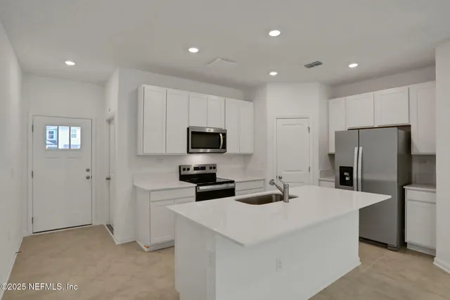 a kitchen with stainless steel appliances a refrigerator sink and microwave