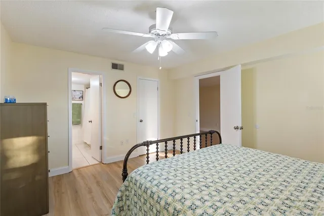 a view of a hallway with wooden floor and a bathroom