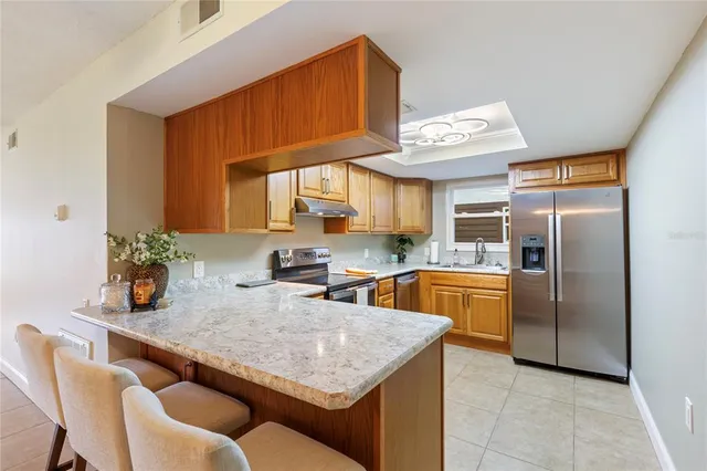 a kitchen with granite countertop cabinets stainless steel appliances and a sink