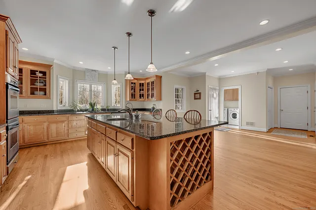 a large kitchen with stainless steel appliances granite countertop a stove and a wooden floors