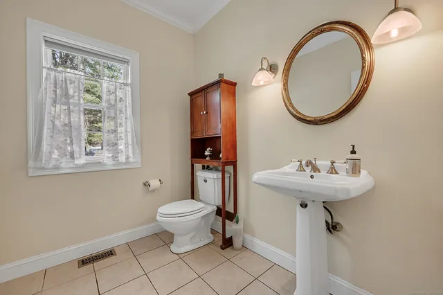 a bathroom with a sink a toilet and a mirror