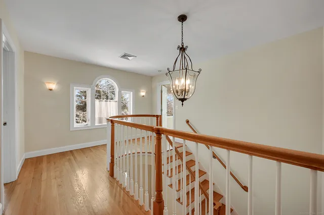 a view of a hallway with wooden floor and staircase