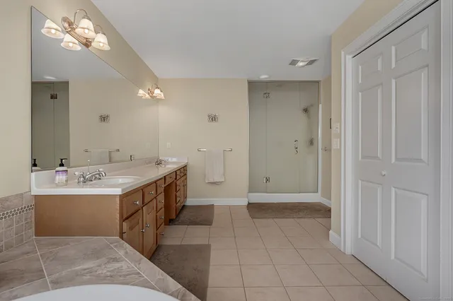 a view of a bathroom with a bathtub a sink and mirror