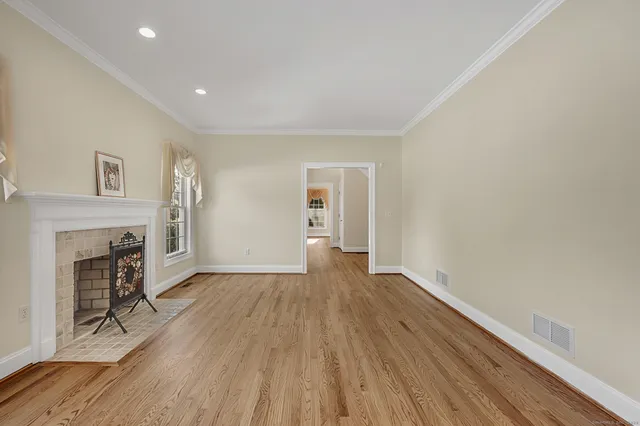 a view of empty room with wooden floor and fireplace