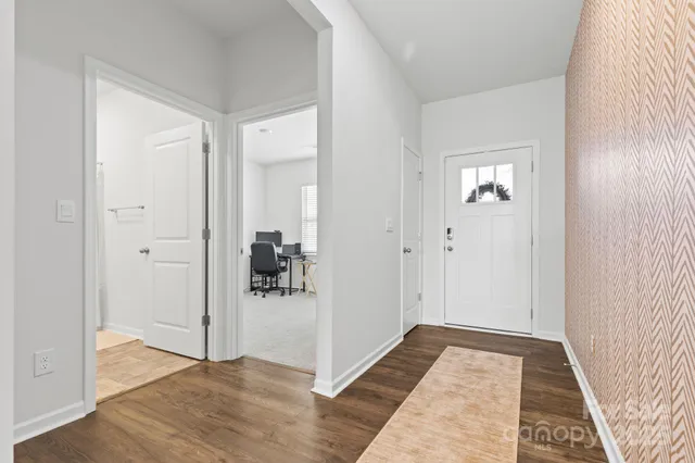 a view of a hallway with wooden floor and closet area