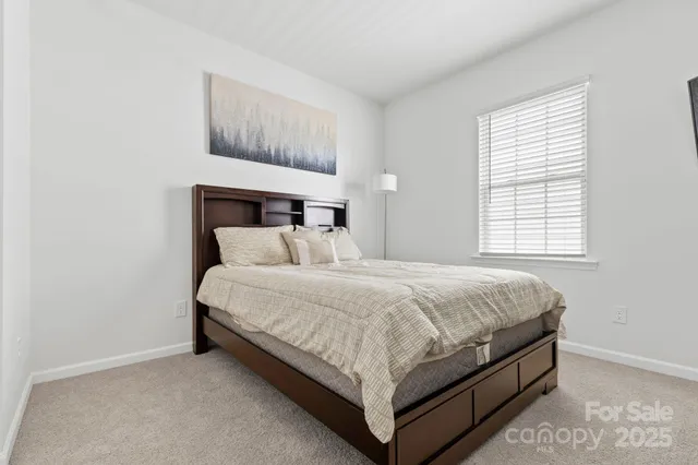 a bed sitting in a bedroom next to a window