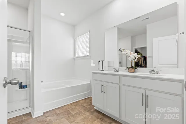 a bathroom with a tub sink and mirror