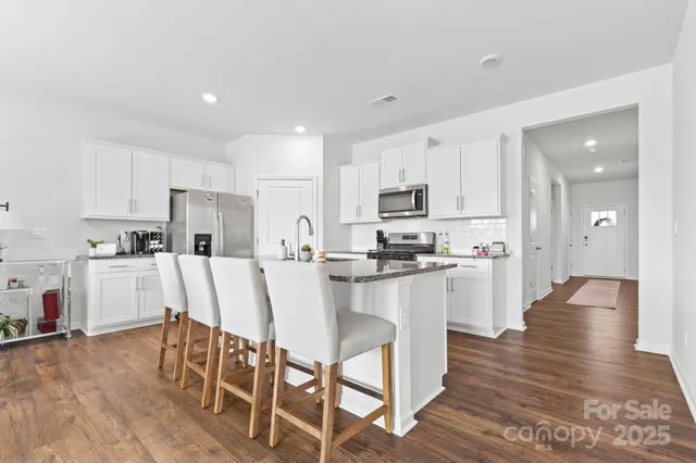 a kitchen with white cabinets and stainless steel appliances