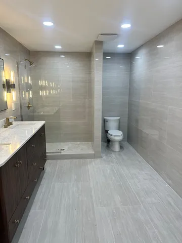 a bathroom with a double vanity sink toilet and shower